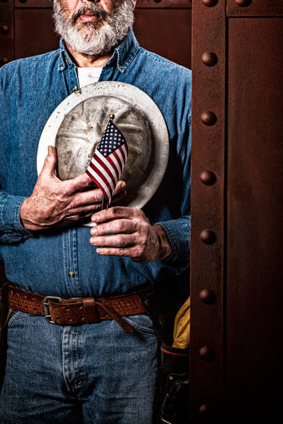 istock A male construction worker holding a small US Flag with hand and hardhat over his heart 1279665775