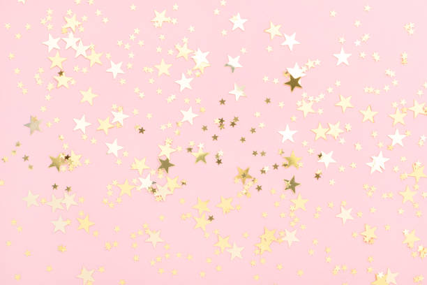 sfondo festoso pastello rosa con coriandoli dorati splendenti a forma di stelle. - gold confetti star shape nobody foto e immagini stock