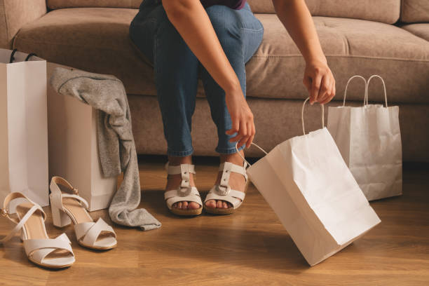 istock woman takes out her purchases from a bag while sitting on the sofa 1279667134