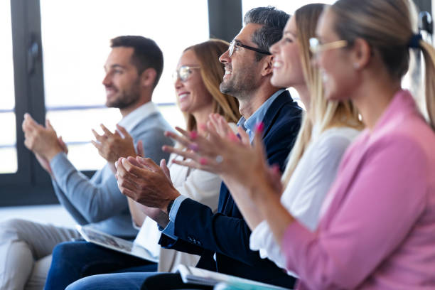 istock Happy business team clapping after listening the conference while sitting on coworking space. 1279669949