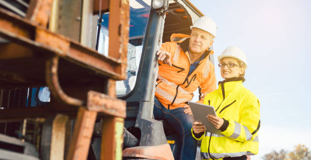 istock Worker in forklift and forewomen looking into task list 1279670195