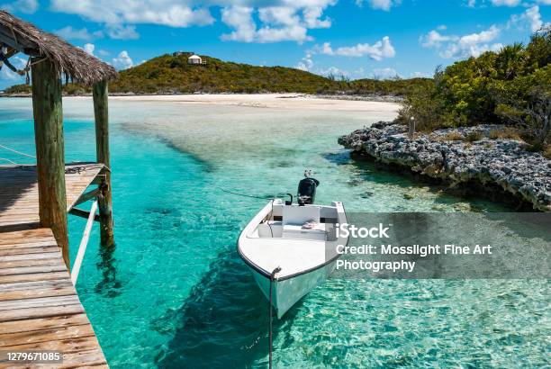 Small Boat Moored Off A Pier Over Turquoise Ocean Waters Near Private Remote Exuma Islands In The Bahamas Stock Photo - Download Image Now