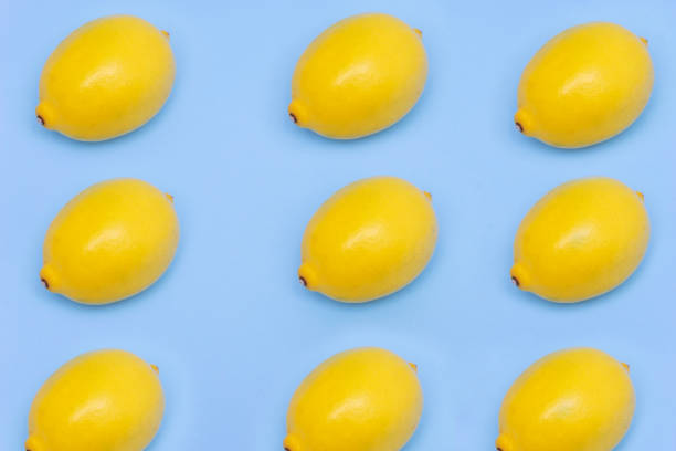 Yellow lemons isolated on blue background stock photo