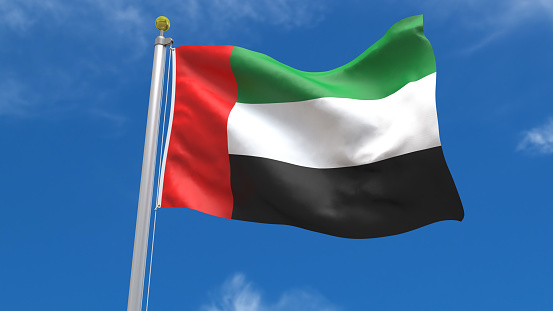 United Arab Emirates Flag Waving, fluttering against the background of the blue sky with silver pole
