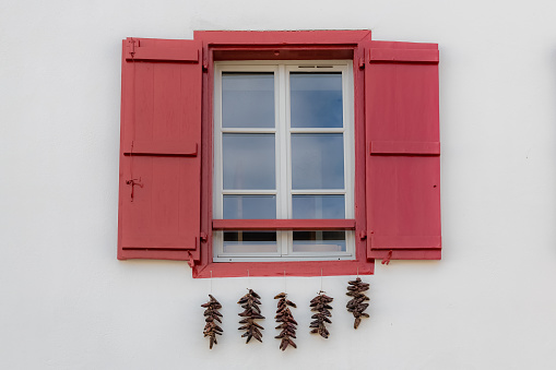 A red-covered window in a white wall