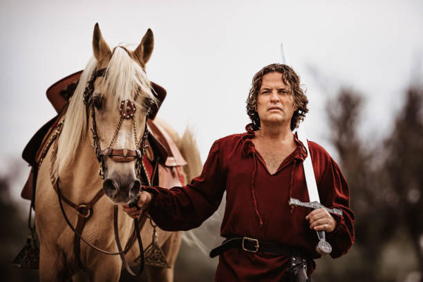 istock Medieval squire together with a Stallion Palomino holding his sword 1279673437