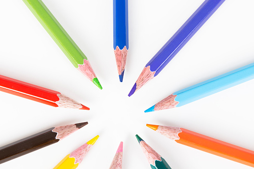 Colored pens are building a circle on white background.