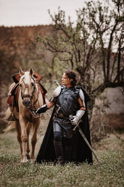istock Black medieval knight walking together with his stallion 1279673592