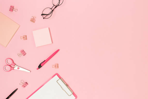 istock Border frame made of scattered office supplies on a pink background. 1279678025