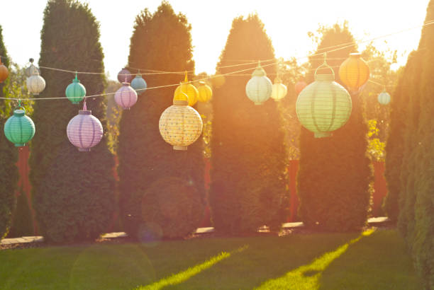 istock Paper lanterns hang on a string. Many lanterns on a background of green thuja. 1279678316