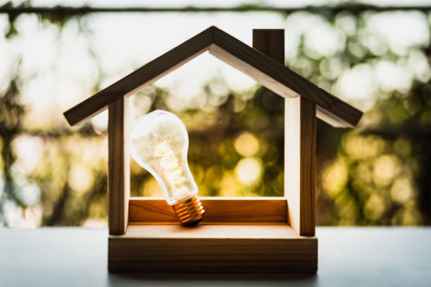 istock Light bulb with wood house on the table, a symbol for construction, Creative light bulb idea, power energy or business idea concept ecology, loan, mortgage, property or home. 1279679308