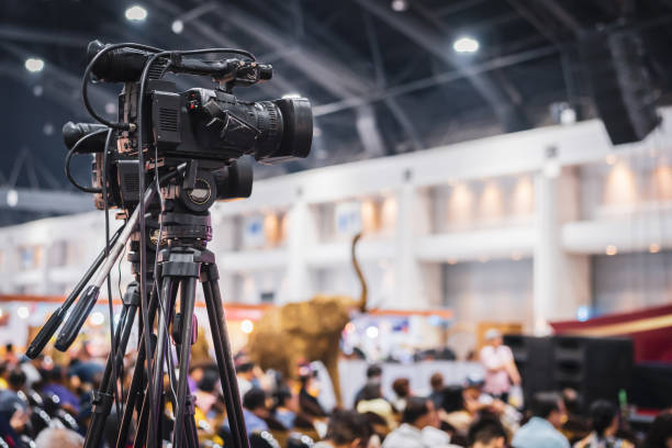 Video camera taking live video streaming with people working background at meeting room. Selective focus.