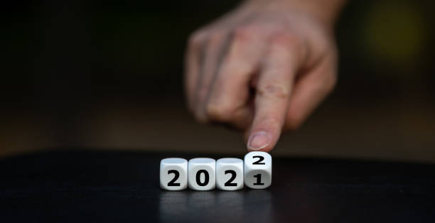 Hand turns dice and changes the year 2021 to 2022.