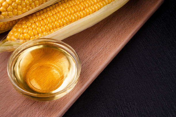 istock Corn oil in a bowl and corn cobs on a wooden board 1279682631
