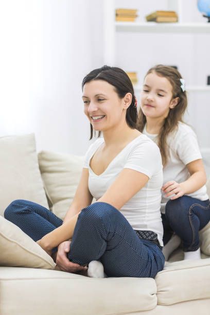istock Happy smiling mother and daughter sitting on sofa. 1279684207