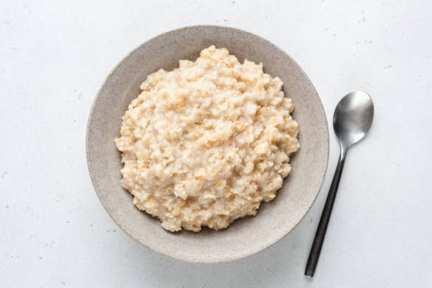 porridge di farina d'avena, cibo sano per la colazione - oatmeal porridge bowl spoon foto e immagini stock