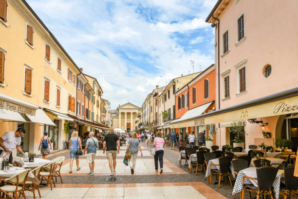 Bardolino, Lake Garda, Italy - September 2018:  People walking past restaurants in a street in the centre of Bardolino on Lake Garda.