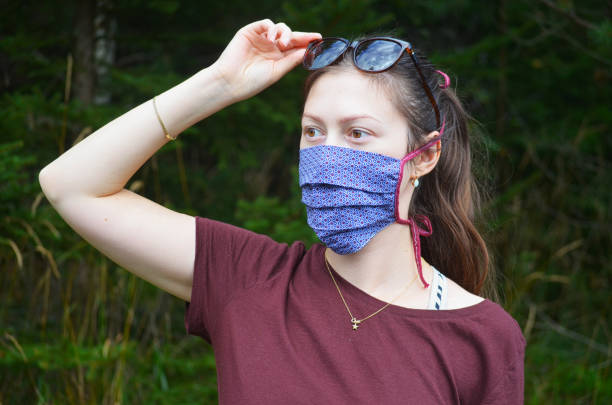 istock Young woman on a walk in nature with reusable face mask 1279689284