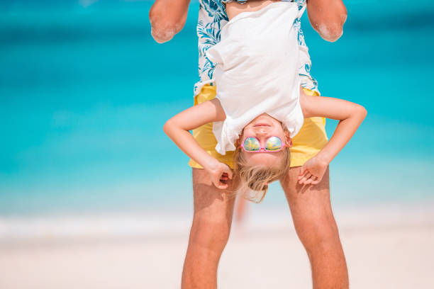 istock Little girl and happy dad having fun during beach vacation 1279689436