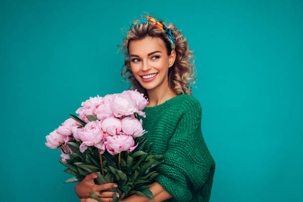 Lovely woman with pink peonies bunch