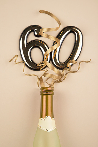 Two champagne glasses and christmas decoration on wooden snow golden bokeh background. Happy New Year Celebration. Selective focus and small depth of field