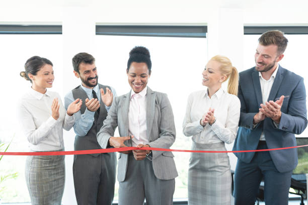 istock Successful business people cutting red ribbon at office 1279697180