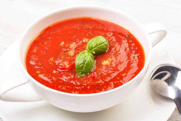 istock Gazpacho in a white plate and basil on a wooden white table 1279697207