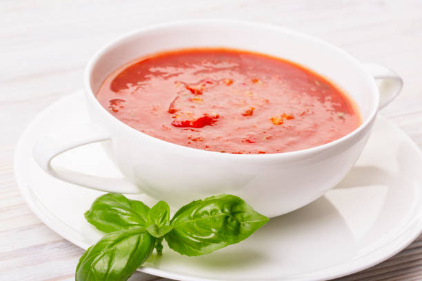 istock Gazpacho in a white plate and basil on a wooden white table 1279697291