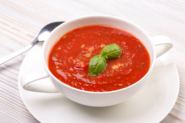 istock Gazpacho in a white plate and basil on a wooden white table 1279697297