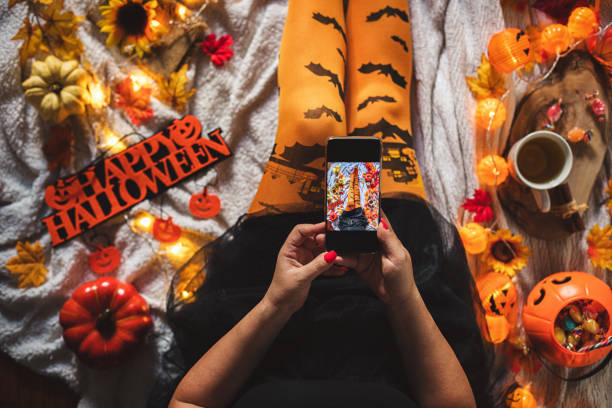 top view of a woman in witch costume taking photos for social media. halloween concept - stockings human leg female women imagens e fotografias de stock