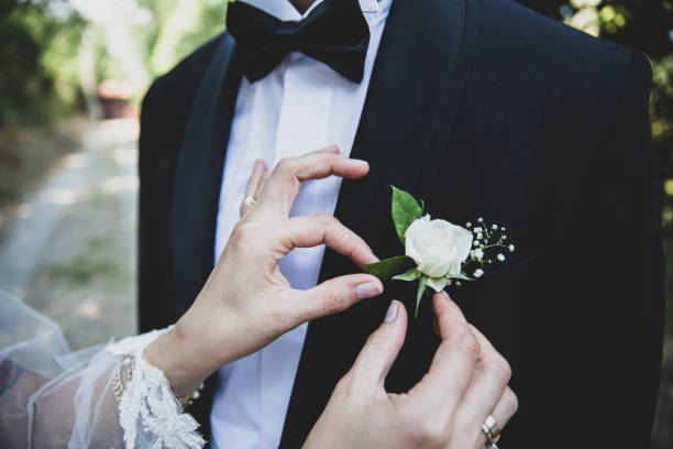 istock The bride is attaching a white rose to the groom's collar outside 1279698397