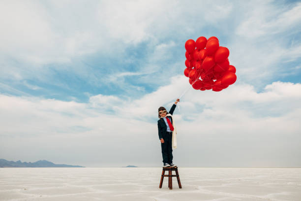 jeune garçon d’affaires avec des ballons - balloon moving up child flying photos et images de collection