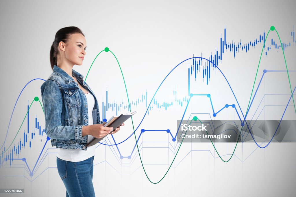 Woman with notebook, financial graphs Side view of young businesswoman with notebook standing near concrete wall with financial graphs. Concept of statistics and business education Adult Stock Photo