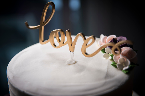 Detail of the dolls on top of the wedding cake, traditional ceremony, bride and groom cutting the cake