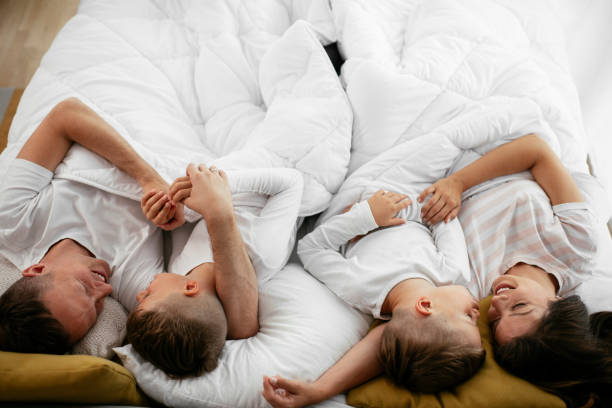 istock Happy parents with sons relaxing in bed. 1279703743