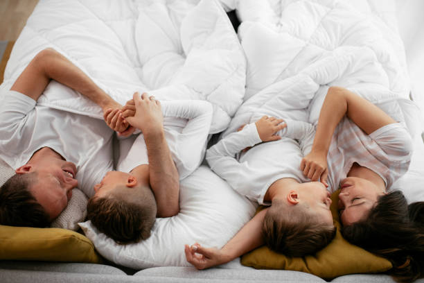 istock Happy parents with sons relaxing in bed. 1279704337