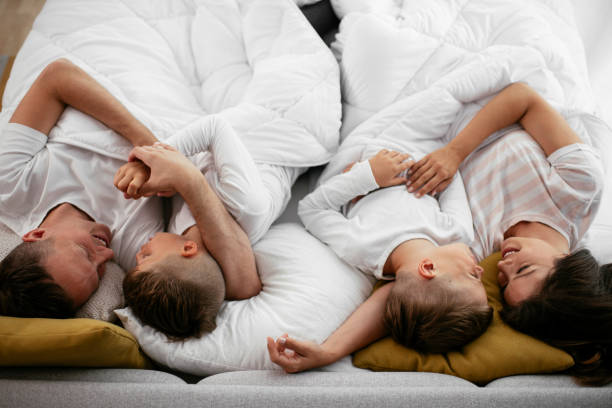 istock Happy parents with sons relaxing in bed. 1279704608