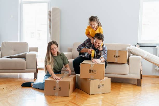 padres e hijos felices jugando en el día en movimiento desempaquetando cajas - no togetherness assistance effortless fotografías e imágenes de stock