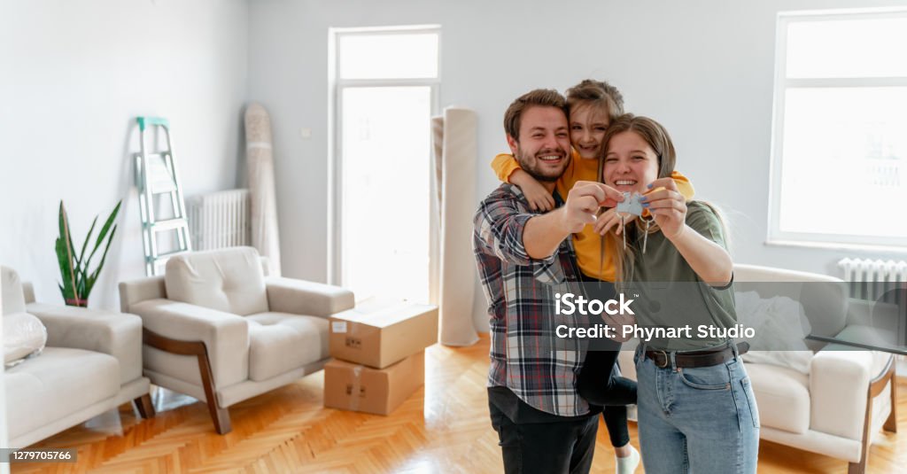 holding keys of their new home Excited American young family show keys to own home, happy  couple  buying first house together, smiling husband and wife purchase new property. Ownership concept Family Stock Photo