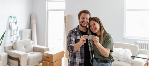 holding keys of their new home Excited American young family show keys to own home, happy  couple  buying first house together, smiling husband and wife purchase new property. Ownership concept computer key stock pictures, royalty-free photos & images