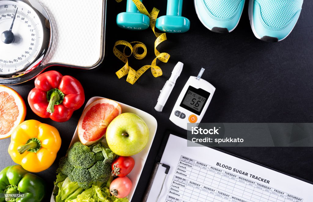 World diabetes day, Healthcare and medical concept. Healthy food including fresh fruits, vegetables, weight scale, sports shoes, dumbells, measure tape and diabetic measurement set on black background. Diabetes Stock Photo