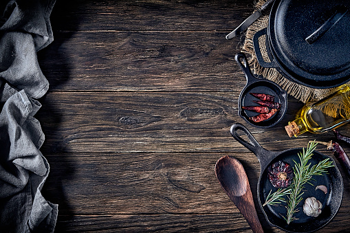 Ready to cook. Iron pan and ingredients on a rustic wooden table with copy space.