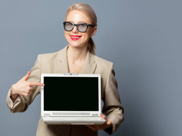istock Style blonde with laptop computer on gray background 1279710044