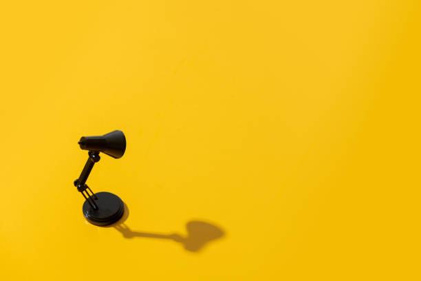 istock Black little lamp on yellow background 1279711000