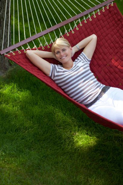 istock Happy Woman Lying In a Red Hammock Outside 1279711183