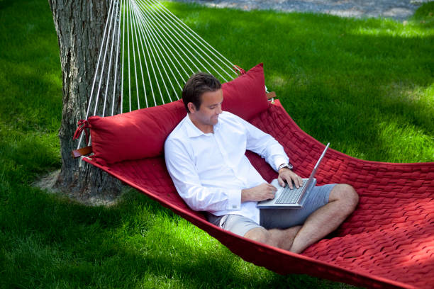 istock Man Working on Laptop at Home in a Hammock. 1279711767