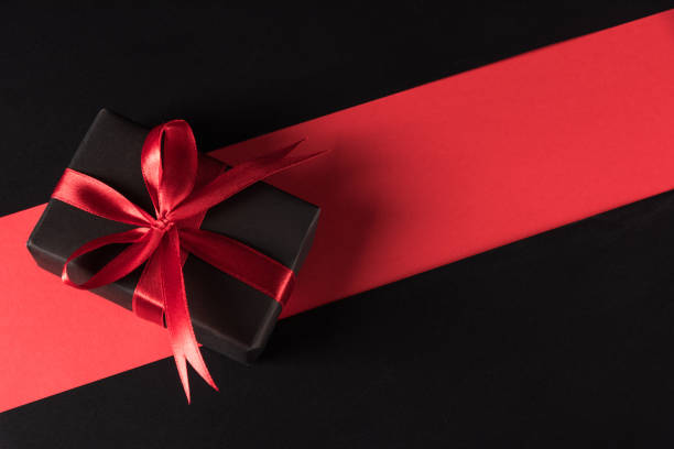 istock Gift box wrapped black paper and black bow ribbon present 1279716342