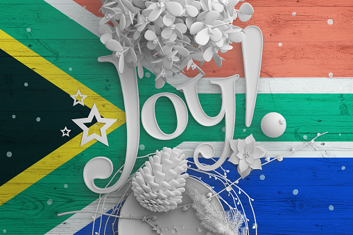 South Africa flag on wooden table with Joy text. Christmas and new year background, celebration national concept with white decor.