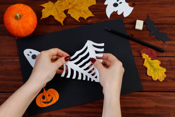 istock Halloween DIY. Step-by-step instructions for cutting a spider web from paper for the holiday. 1279726671