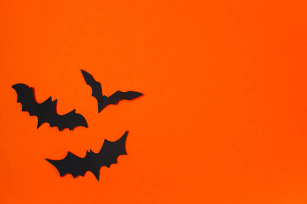 istock Halloween concept. Festive decorations. Bats on orange background. 1279726706